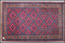 A Persian Quchan prayer rug being hand knotted having central mihrab with geometric lozenge design