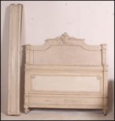 A late 19th early 20th century painted shabby chic French double bed having carved scrolling detail