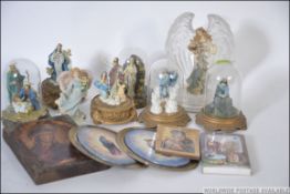 A collection of religious figurines in glass globes together with wooden panel icon etc.