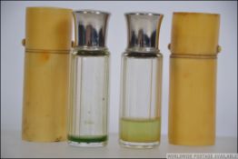 A pair of Edwardian glass perfume bottles having screw on polished metal lids,