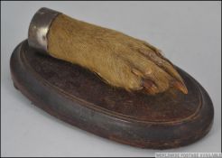 A Victorian white metal mounted collared deers foot applied to a wooden socle plinth base.
