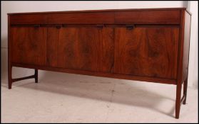 A retro teak long Danish influence sideboard having a central drop centre cupboard flanked by a