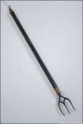 A 19th century metamorphic / telescopic brass ebonised toasting fork.