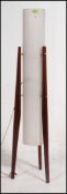 A 1960's vintage teak rocket lamp raised on angled supports with white tall cylinder shade.