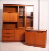 A 1970's G-Plan style teak upright sideboard display cabinet having cupboards to the base with