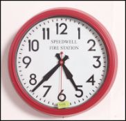 A retro wall hanging clock with a fire engine red case having notation to the face for Speedwell
