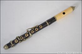 A rosewood and ivory 6 keyed piccolo, the finger holes and mouthpiece ringed with ivory,