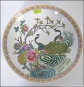 A 20th cenutry Chinese famille rose charger with yellow geometric borders having handpainted