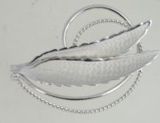 A contemporary silver white metal brooch with roller clasp in the form of feathers with spiral