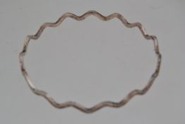A 925 silver bangle in a planished wave form. Marked 925.