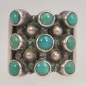A retro 1970's brutalist silver 925 and turquoise set ladies dress ring inse with 9 round turquoise
