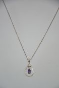 A silver and Art Nouveau amethyst adorned pendant and necklace chain. The pendant with swing centre.