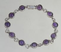 A silver 925 and amethyst set ladies bracelet with chain linked spacers and lobster claw catch.