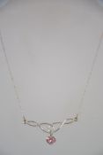 A silver ladies fine link necklace and Art Nouveau pendant with drop heart pink stone centre.