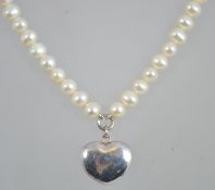 A pearl and silver necklace having a silver heart pendant, the pearl chain with lobster claw clasp.