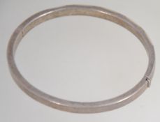 A silver and mother of pearl inlaid bangle being stamped 925 with push clasp.