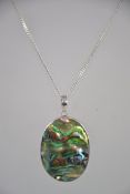 A silver ladies necklace and abalone large inset oval pendant. The chain with lobster claw clasp.