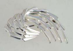 A contemporary silver ladies brooch in the form of a crashing wave with pin to verso.