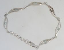 A contemporary silver 925 bracelet chain with clear garnet stones and swirl spacers with lobster