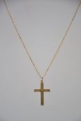 A 9ct gold crucifix - cross pendant and necklace chain. The cross being chase decorated.