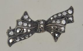 A vintage silver brooch in the form of a a bow having inset marcasite stone work and pin back.
