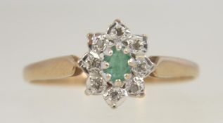 A 9ct gold, emerald and diamond ring. The central oval emerald with diamond surround.