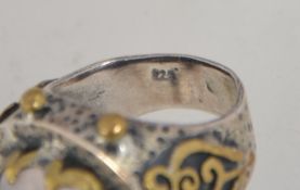 A vintage 925 silver ring set with a large oval faceted rose quartz with yellow metal granulation