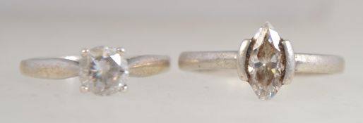 A silver single stone round cut cz solitaire ring together with another single stone ring. Sizes M.