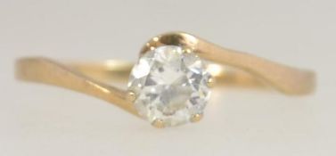 A hallmarked 9ct gold ring with a large prong set clear stone approx 25pts on a cross over band.