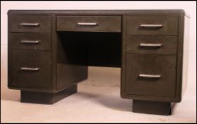 A vintage mid century twin pedestal steel desk in khaki green having a central long drawer flanked