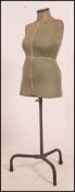 A 1950's Singer tailor's dress makers dummy standing on an adjustable tubular metal stand on tripod