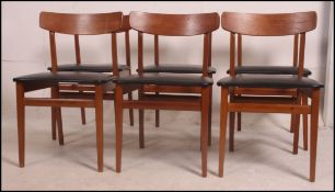 A set of 6 1970's retro teak propeller back dining chairs raised on squared legs having the