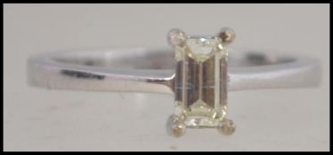 An 18ct white gold emerald and cut diamond ring. Approx 0.