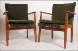 A pair of 1950's retro vintage Parker Knoll armchairs raised on angular show wood frames being