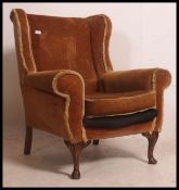 A vintage mid century Parker Knoll wing back armchair raised on Queen Anne cabriole legs finished