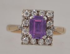 A 9ct gold and amethyst ladies dress ring, the central amethyst surrounded by clear cz stones.