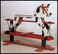 A vintage mid century painted childs rocking hours in red and white with dappled effect.