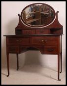 An Edwardian mahogany inlaid dressing table with oval swing mirror.