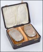 A pair of cased gentlemans silver hallmarked hair brushes,