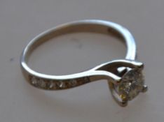 A 585 marked 14ct white gold solitaire ring with diamond encrusted shoulders and central stone