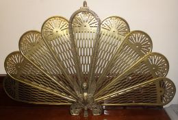A 20th Century brass metamorphic peacock firescreen having eight fan out leaves with a Griffin base