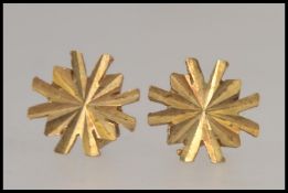 A pair of 9ct gold sunburst stud earrings each hallmarked to the stud post