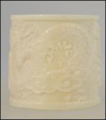 A Chinese carved bone bowman's ring depicting traditional Oriental scenes H3cm