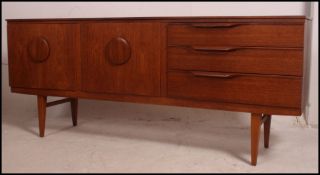 A 1970's retro Danish influence teak sideboard raised on shaped legs having an inverted bow front