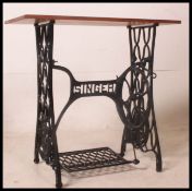 A vintage upcycled cast iron singer sewing machine treddle base have polished wooden top