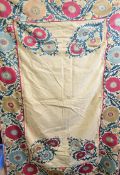 A 19th century silk embroidered Suzani on linen ground with inscription navigating the plain field