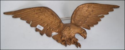 A vintage cast metal wall mounted gilt Eagle in full flight with talons ready to pounce W71cm