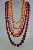 A collection of amber style and bead necklaces dating to the mid 20th century.