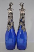 A pair of believed Bristol blue glass decanters with silver plated grape and vine decoration and