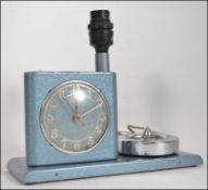 A vintage unusual metal clock, lamp and ashtray combination.